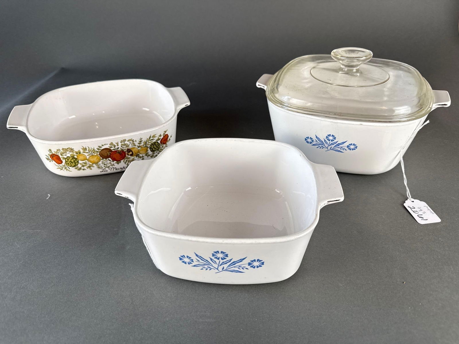 3 pyrex dishes: (1) 8" x 3-3/4" with lid, (1) 6-1/2" both cornflower. (1) 8" La Marjolaine Low Estimate: 20.00 High Estimate: 40.00