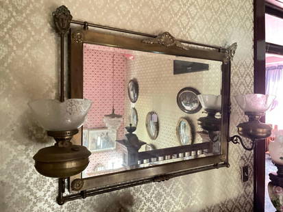 Large brass mirror with kerosene lamps attached to both sides: 43" x 31" Low Estimate: 100.00High Estimate: 300.00
