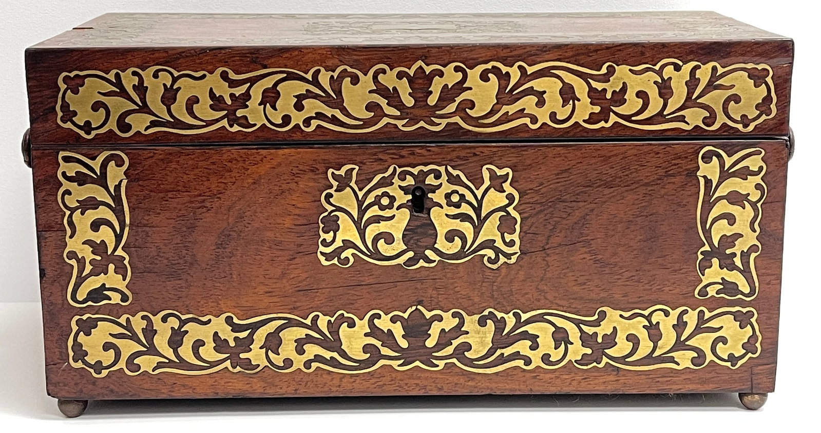 19th Century Brass Inlaid Rosewood Tea Caddy: Two compartments with wood lids, and the center a round jar. Overall good condition, see photos. Measures 6.25 inches high,12 inches wide, 6 inches deep.
