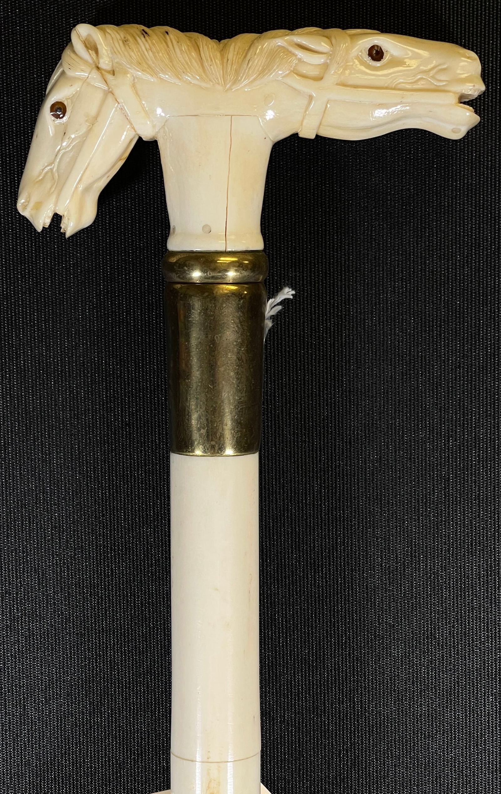 Vintage Carved Bone Walking Stick Depicting Double Horse Head: Bone shaft, brass tip. 37.75 in long. Some sections separated, please see photos.