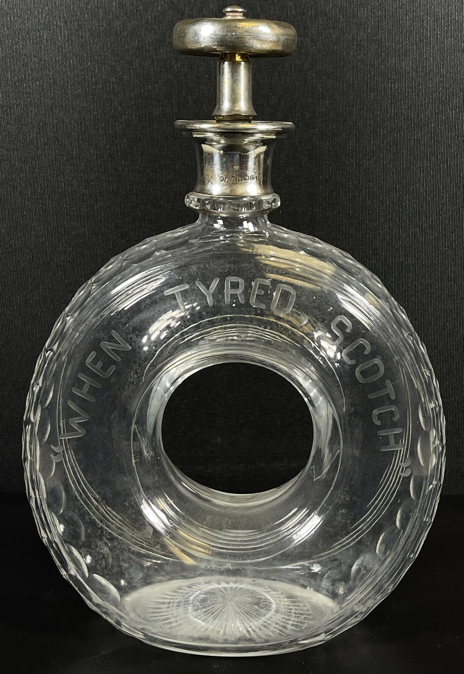 Birmingham Hukin & Heath Cut Glass and Sterling Silver When Tyred Decanter: A Hukin & Heath Cut Glass and Silver When Tyred, Scotch Decanter, Birmingham, England, circa 1928 Marks: (lion passant), (anchor), H&H, AOD. Measures 10.5 inches to the top of the stopper, 8.75 to the