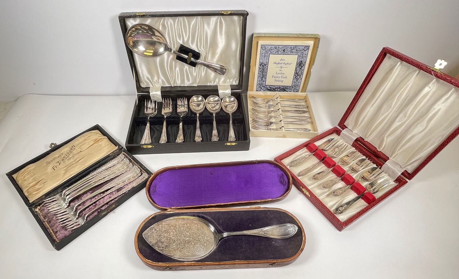 Mixed Lot of Silver Plate Forks and Spoons: To include set of 6 pastry forks in original box set of loxley pastry forks in original box, set of 10 Rogers bros seafood forks in original box, W.M. Rogers Pie server in original box, and english de