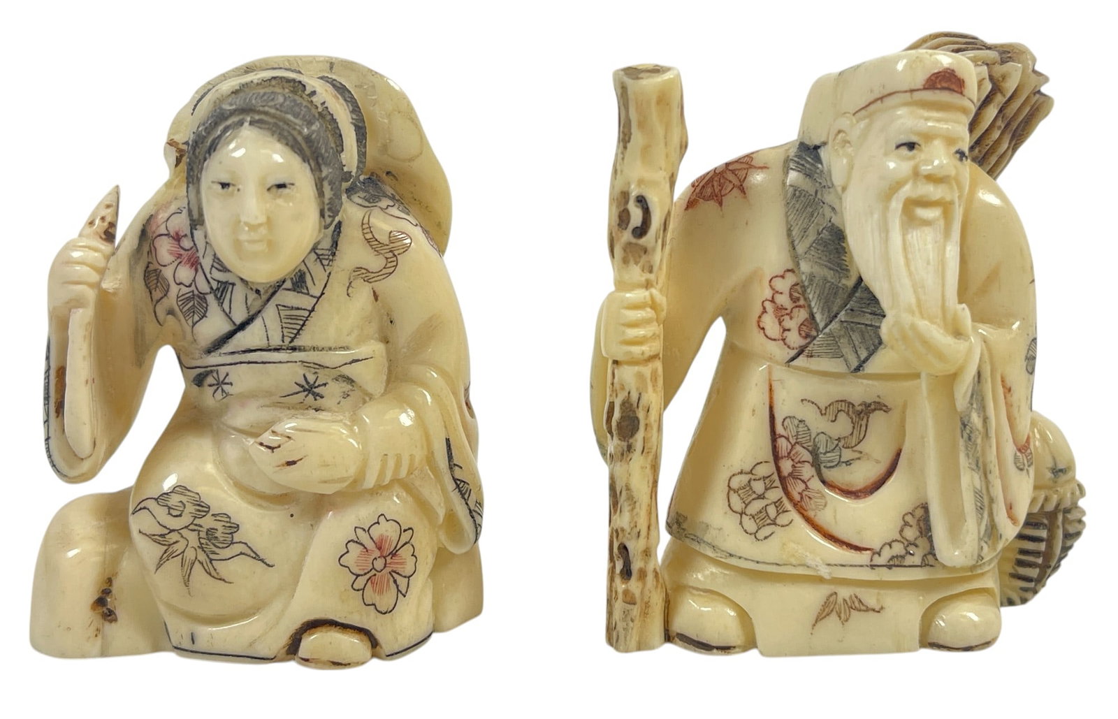 Lot of 2 Asian Figural Netsukes: Man and woman in traditional garb. Marked on the bottom. Tallest measures 2 inches high.