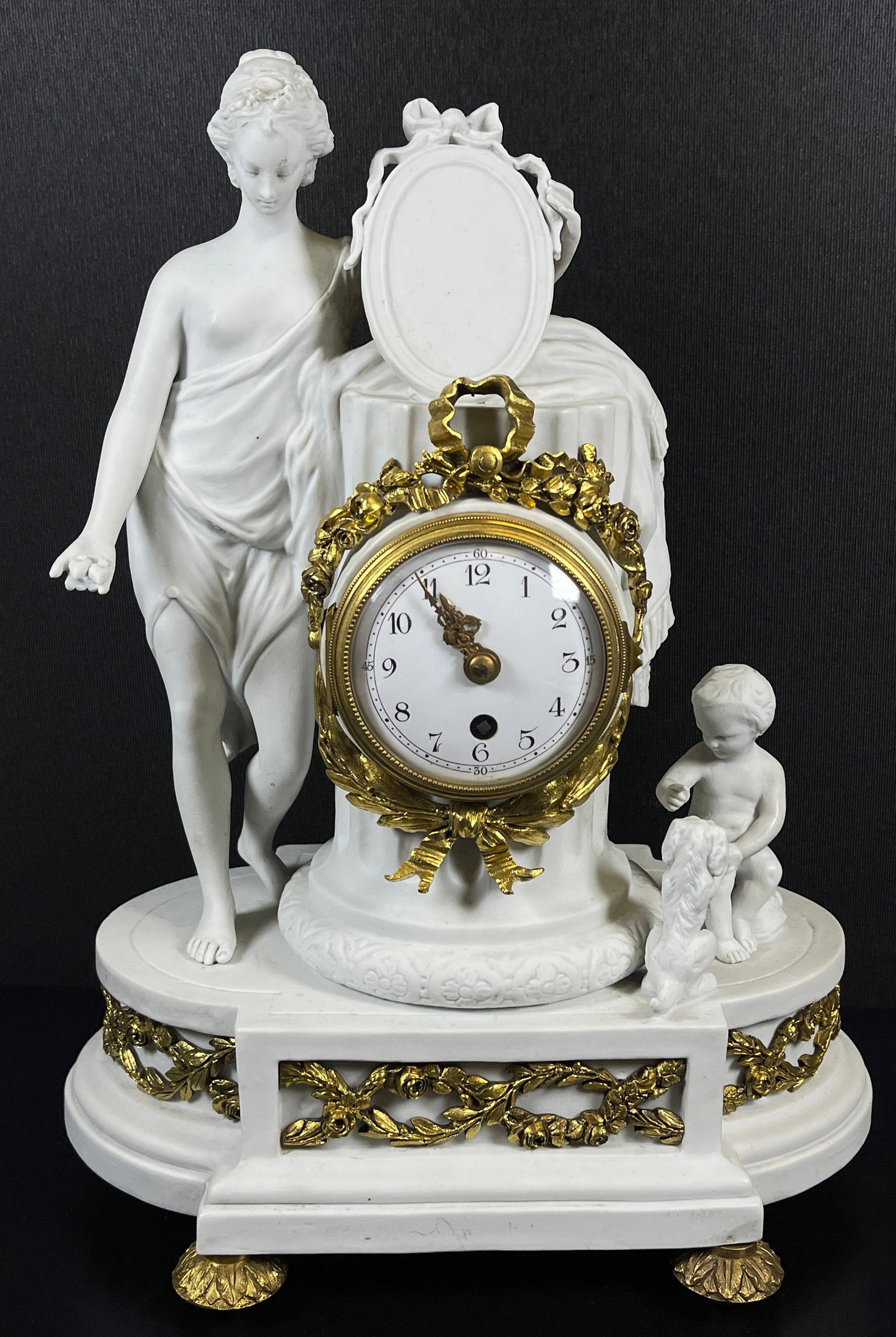 Louis XVI Sevres Style Bisque & Dore Bronze Figural Clock: Dore bronze feet, mounts and clock surround. Porcelain dial, no key. Overall good condition, fingers on left hand broken off. Measures 12.5 inches high, 9 inches wide, 6.5 inches deep.