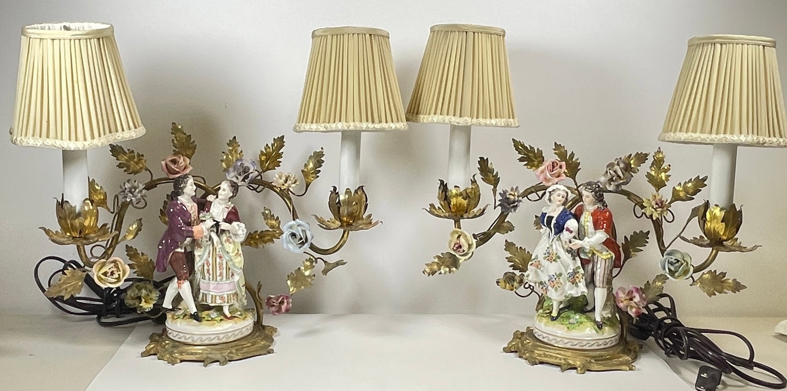 Pair Dore Bronze Mounted Porcelain Grouping Mounted as Lamps: Porcelain flower sprays behind each couple. Double candlestick converted to boudoir lamps. Overall measurement 13.5 inches high, 13.5 inches wide, 5 inches deep. Overall very good condition, see photo
