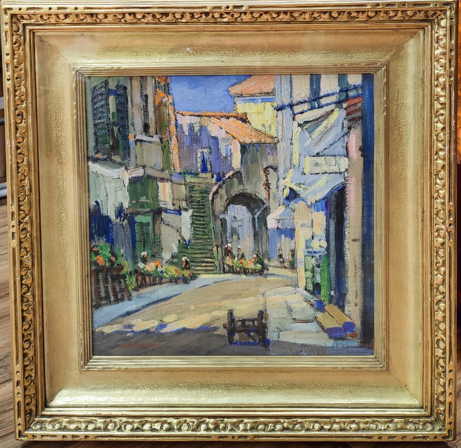 Edwin H. Gunn O/B Village Square Titled Flower Mart: Edwin H. Gunn (New York, 1876 - 1940) O/B in excellent condition and beautifully framed in a decorated gilt frame. The painting is glazed over the frame, giving the work a 3D feel. Painting is noted o