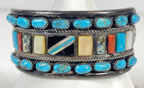 Attb. Leroy Thomas Native American Sterling Silver Multi Gem Cuff Bracelet: Inlaid with turquoise, Black Onyx, mother of pearl and coral, the art of Navajo jewelry further advanced by an acknowledged master. Unmarked, but atrributed to Leroy Thomas. Bracelet measures 5.75 inc