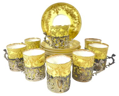 c1903 English Sterling Silver & Staffordshire Cup & Saucer Set: Staffordshire egg shell coffee set. Includes eight demitasse cups and saucers with ornate silver holders, inside of a holding case. Staffordshire demitasses with floral designs on the top half. Staffo