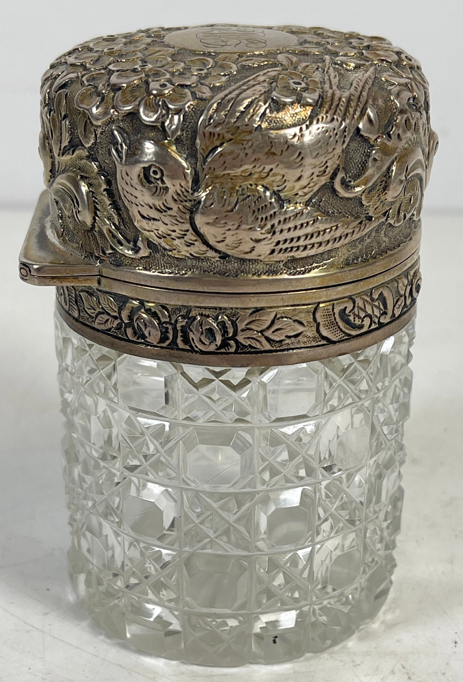 c1899 London Repousse Sterling & Crystal Scent Bottle: Repousse with flowers and birds. Maker Sampson Mordan & Co, lion passant, date for 1899. Measures 3.75 inches high, 2.375 inches across the bottom. Overall fair condition, chip along the bottom rim, p