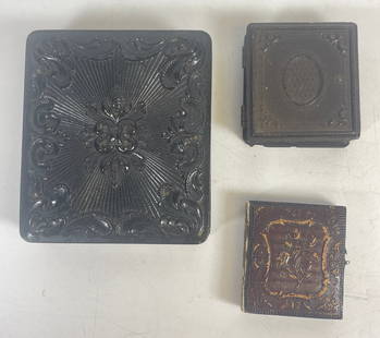 (3) Gutta Percha Photo Cases with Sixth Plate Daguerrotype: One sixth plate daguerrotype in gutta percha frame, missing velvet inset, two smaller frames, one gutta percha the other leather. Smaller measure 2 inches x 2 inches. Overall fair condition, please se