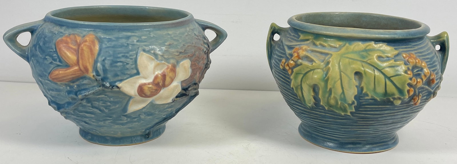 Lot of 2 Roseville Art Pottery Small Jardinieres: To include Magnolia 665-4, and Bushberry 657-4. Overall good condition, no chips or cracks.