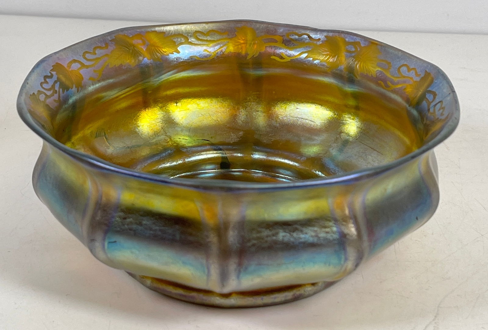 c1910 LC Tiffany Studios engraved Favrile Bowl: Leaf pattern engraved to inside rim. Marked on the bottom. Bowl has a crack running through it, please see photos. Measures 2.5 inches high, 6.125 inches in diameter across the top.