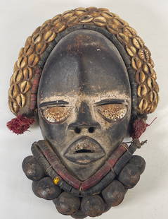 African Ivory Coast We Mask Wobe Culture: Wood, cowries, beads, metal bells and fabricH.: 30; L.: 19; Thickness: 7.5 cmDark wooden mask, eyes are sculpted, his beard manifested by a series of metal bells and threads of glass beads. His hair i