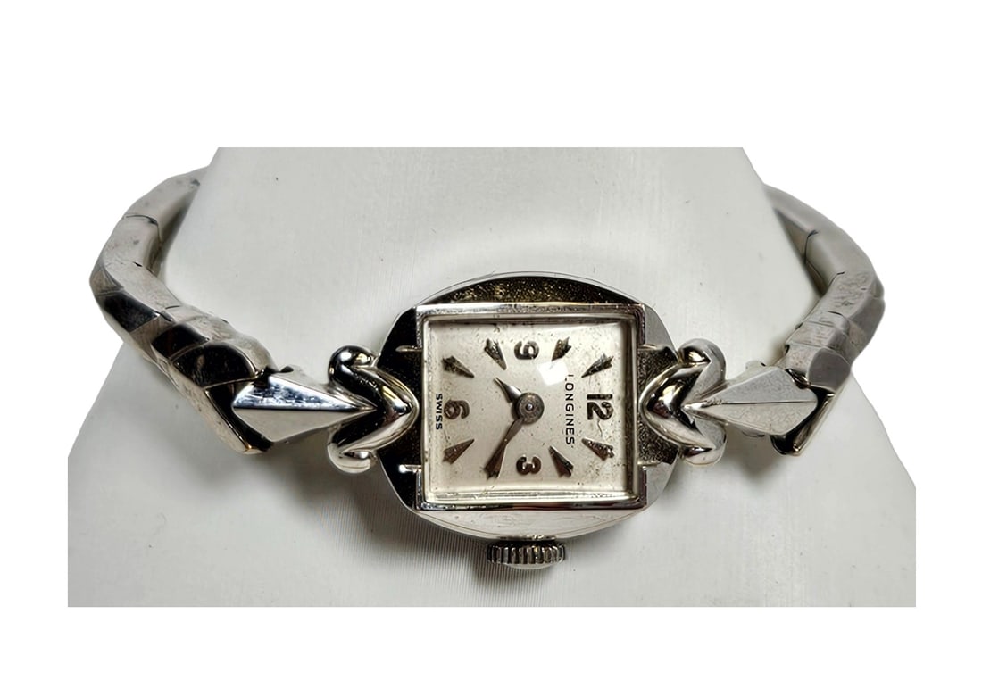 c1940 Ladies 14k White Gold Longines Watch: Face measures 15mm wide to the screw, 33 mm long to the ends. Stretchable stainless steel band. Overall good working condition at time of description.