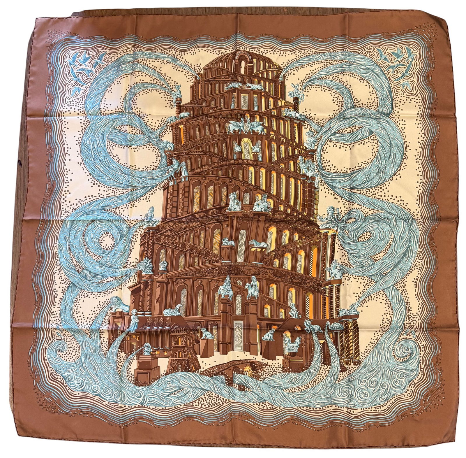 Hermes Les Rivières de Babel Silk Scarf New in Bag: Designed by artist Annie Faivre, the silk twill with rolled and hand stitched edges, with a color palette of brown, gold, and blue. New, never worn. Measures 90cm x 90cm.