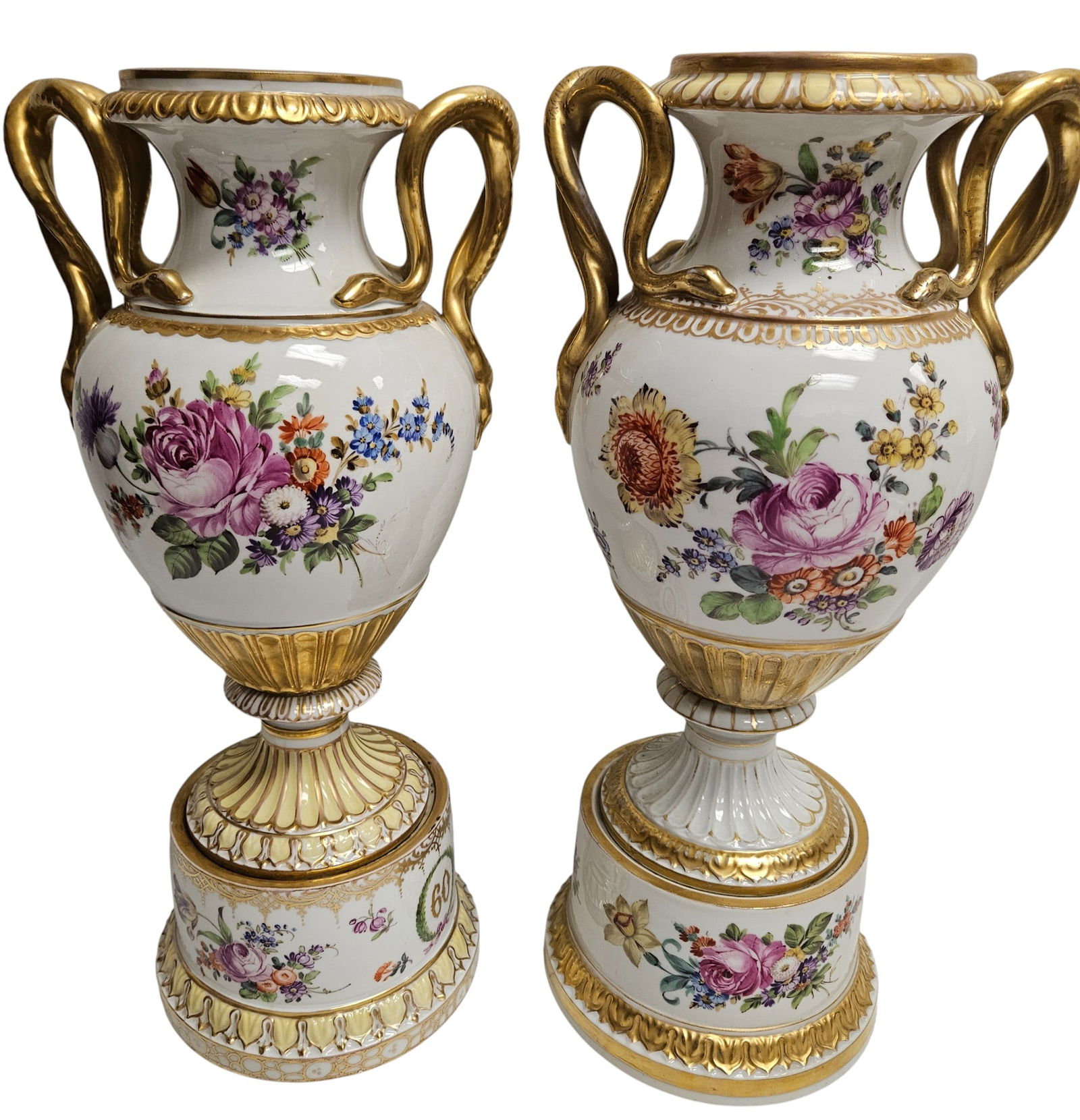 19th Century Pair Meissen Style Porcelain Urns with Snake Handles: Handles distinctively shaped as coiled snakes detailed in gold, body adorned with naturalistic floral decorations. Urns measure approx 16 inches high, approx 7 inches at its widest. Overall good condi