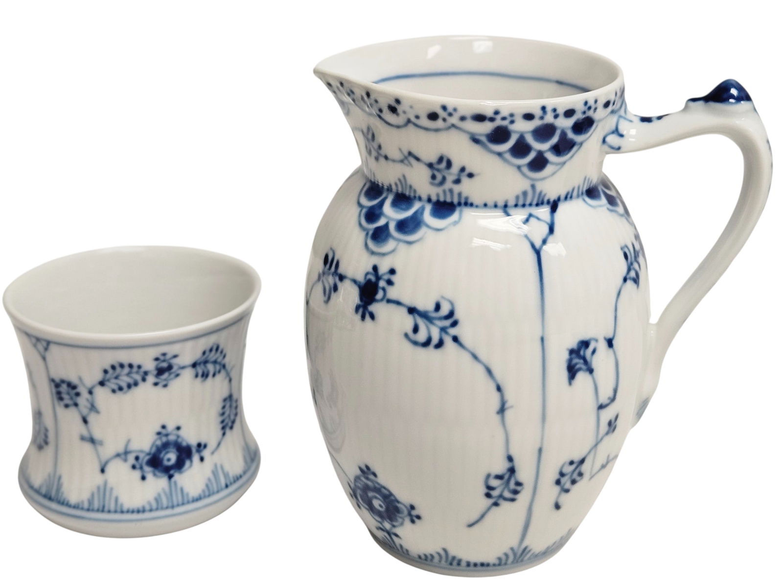 Lot of (2) Royal Copenhagen Blue Fluted Porcelain Items: To include small pitcher dated 1980-1984 (5.25 inches high, number 561) and fluted cup or toothpick holder dated 1980-1984 (2.5 inches high). Overall good condition, no chips or cracks.