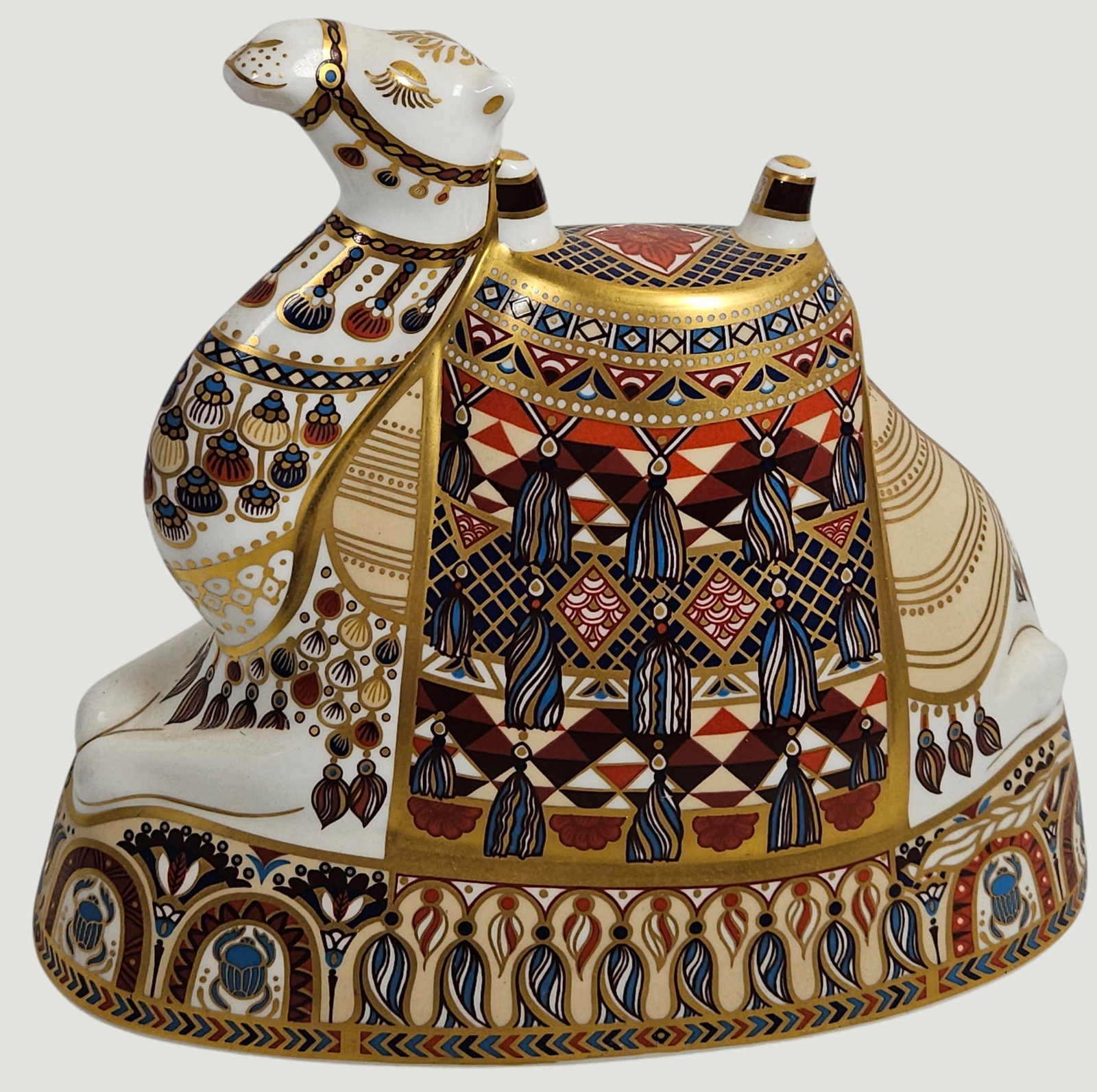 Royal Crown Derby Imari Porcelain Camel: Features this humped animal in seated pose. Richly decorated with geometric shapes, tassels, open lattice and intricate floral inspired motifs in striking shades of reds and blues, against a crisp