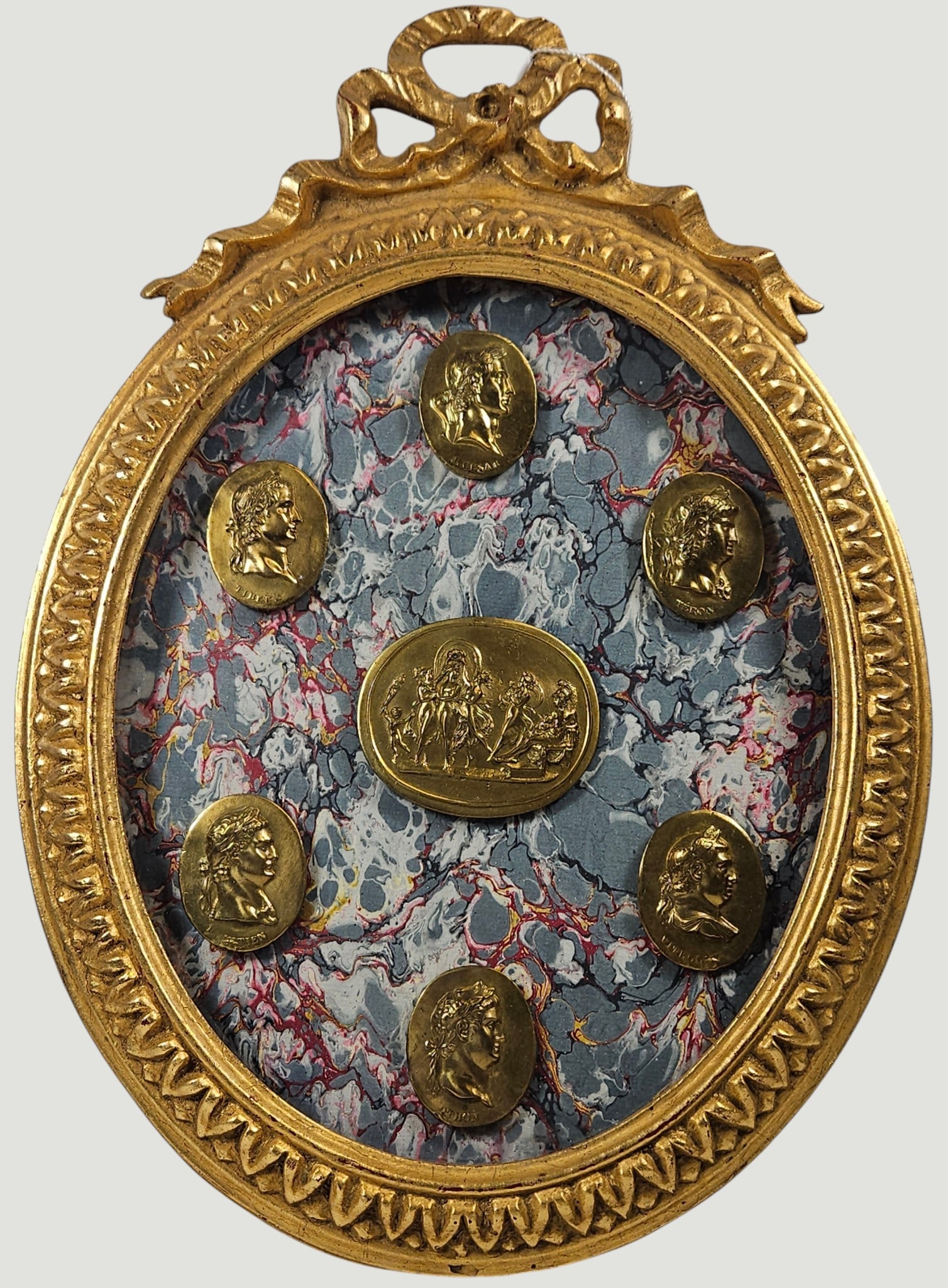 (7) Grand Tour Style Intaglio Medallions under Glass: (6) smaller and one larger in the center. Made in London. Frame measures 16 inches high, 11.5 inches wide. Overall good condition, please see photos.
