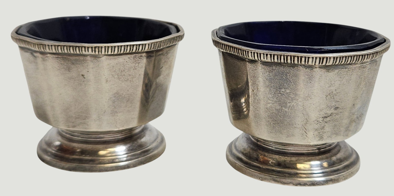 Pair c1939 Birmingham England Sterling Silver Cobalt Lined Salts: Hallmarked on side, maker Bravingtons Ltd. Measures 1.375 inches high, weight of silver only 50.2 grams (1.6 ozt). Overall good condition, no chips or cracks to the glass. Please see photos.