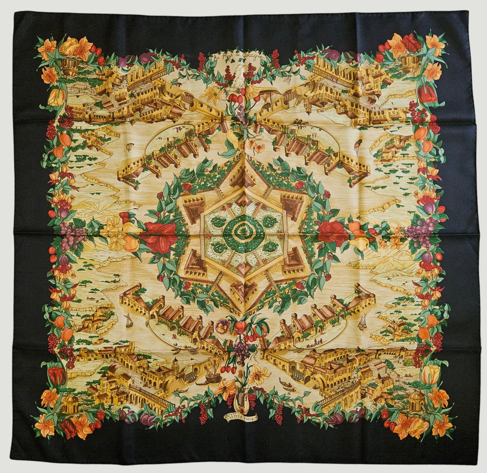 Hermes Au Pays de Cocagne Silk Scarf: Designs a utopian paradise motif that first appeared in 2000. Black ground. 90cm x 90cm. Overall excellent condition. Provenance from an extensice collection from an upper east side Manhattan estate.