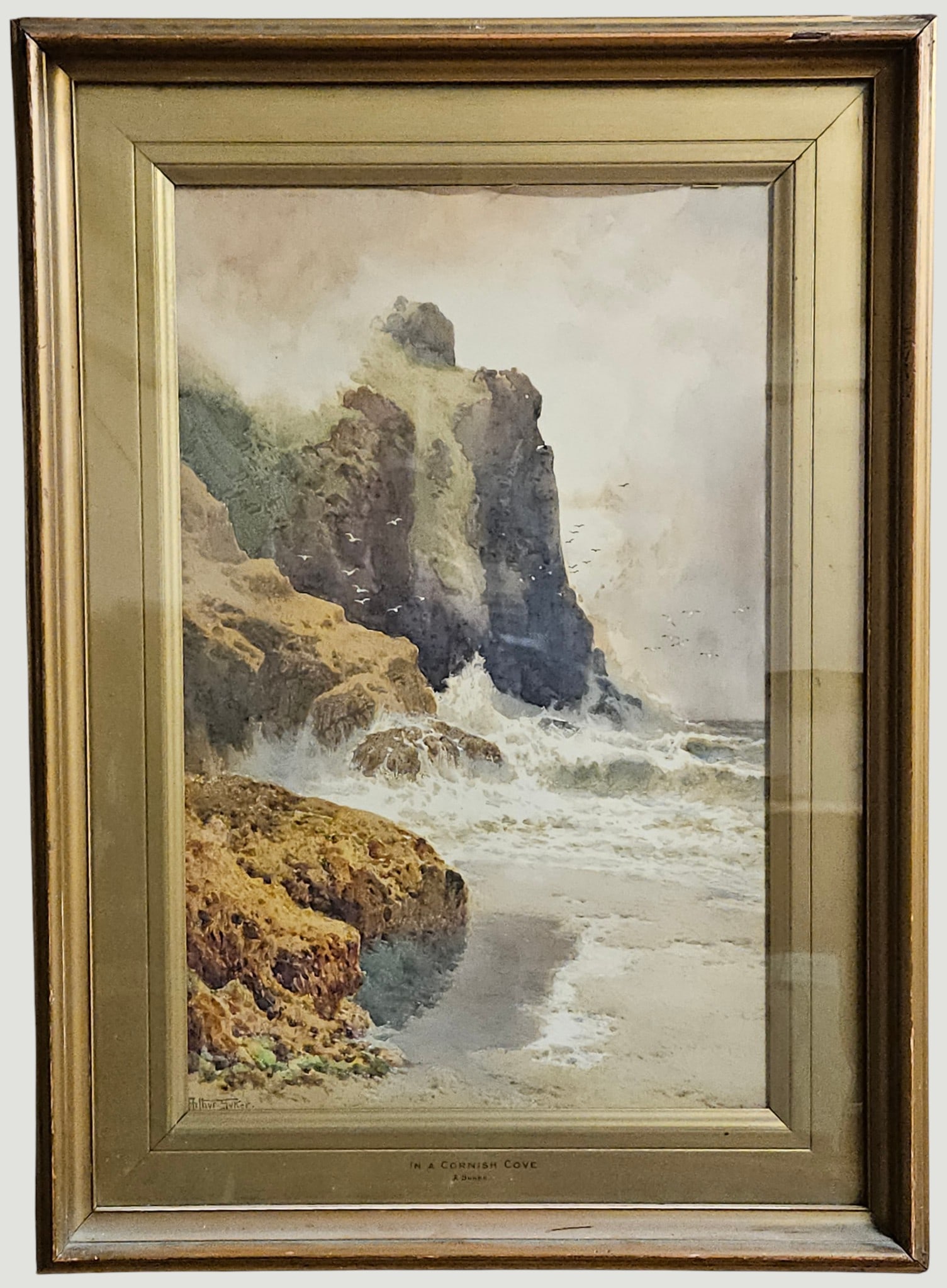 Arthur Suker (Brittish, 1857-1902) Watercolor 'In a Cornish Cove' Landscape: Finely painted scene, depicting towering coastal cliffs, wild crashing waves, and seagulls taking flight. Titled 'In a Cornish Cove'. SIgned lower left, titled on frame, center. Frame measures 30.75