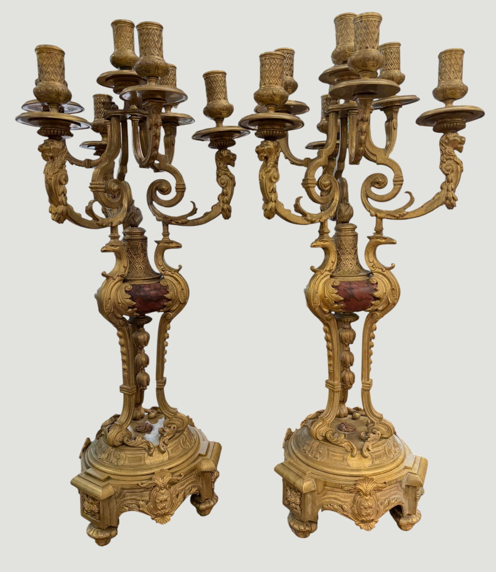 Pair 19th Century French Napoleon III Gilt Bronze 7 Arm Candelabras: Gilt bronze and rouge marble central column, with classical foliate motifs and lion heads. They measure 27.5 inches high, 11 inches wide. Overall good condition, please see photos.