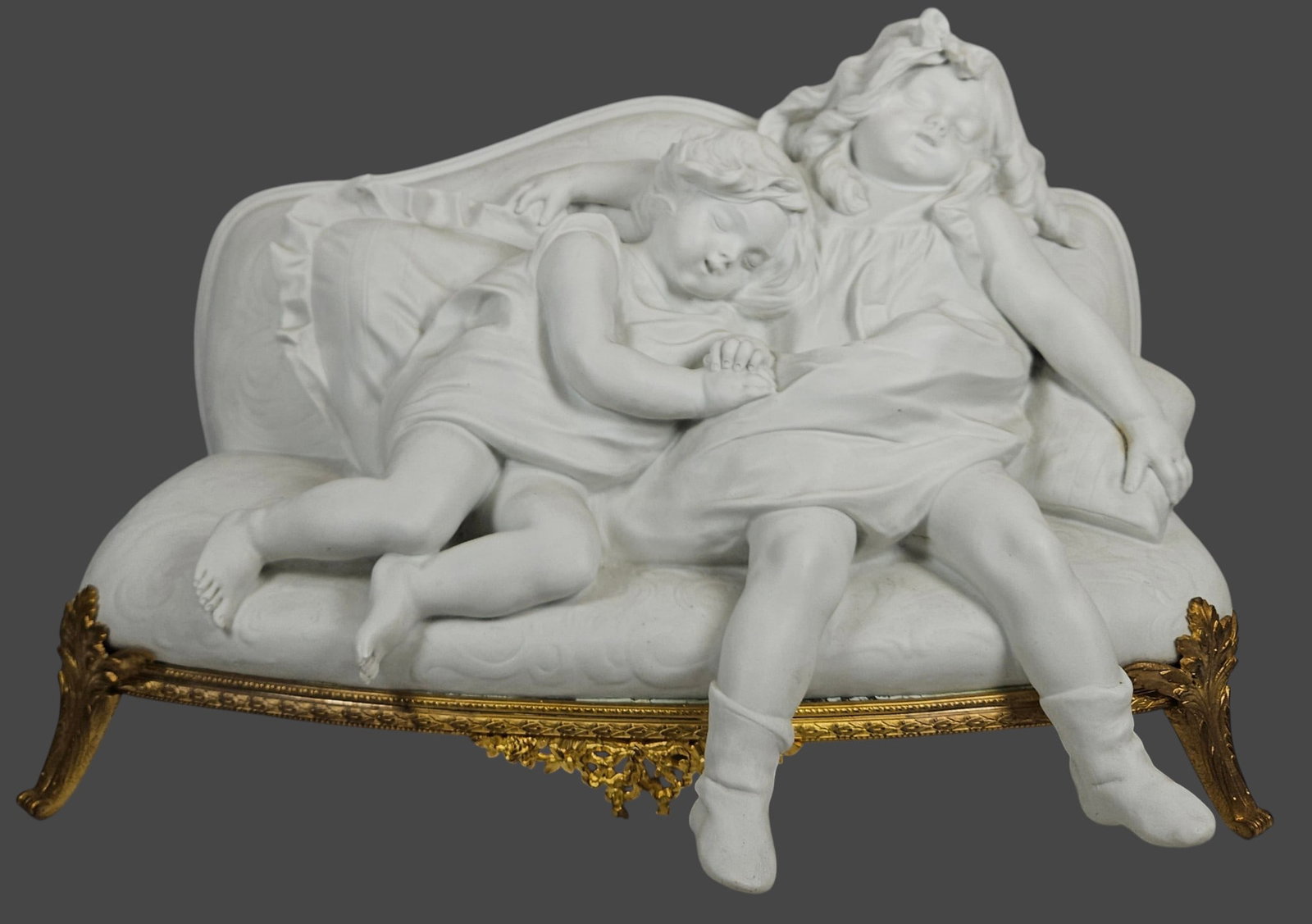 19th Century Aristide Rousaud (1868-1946) Bronze Mounted Bisque Grouping Sleeping Children: Beautiful Sèvre biscuit and gilt bronze sculpture forming two little girls sleeping on a cozy sofa with a cushion all in biscuit supported by a Louis XV style gilt bronze sofa structure. Signed A. Ro