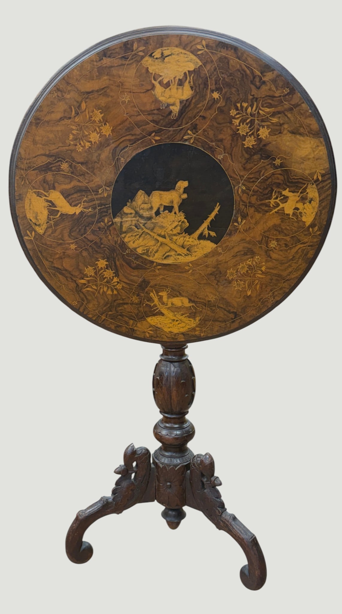 19th Century Black Forest Marquetry Inlaid Tilt Top Table: Features a marquetry hunting scene and wildlife motifs. Measures 39 inches high when tilted up, 27 inches high when flat like a table - 22 inch diameter. Overall good/fair condition - repair to the