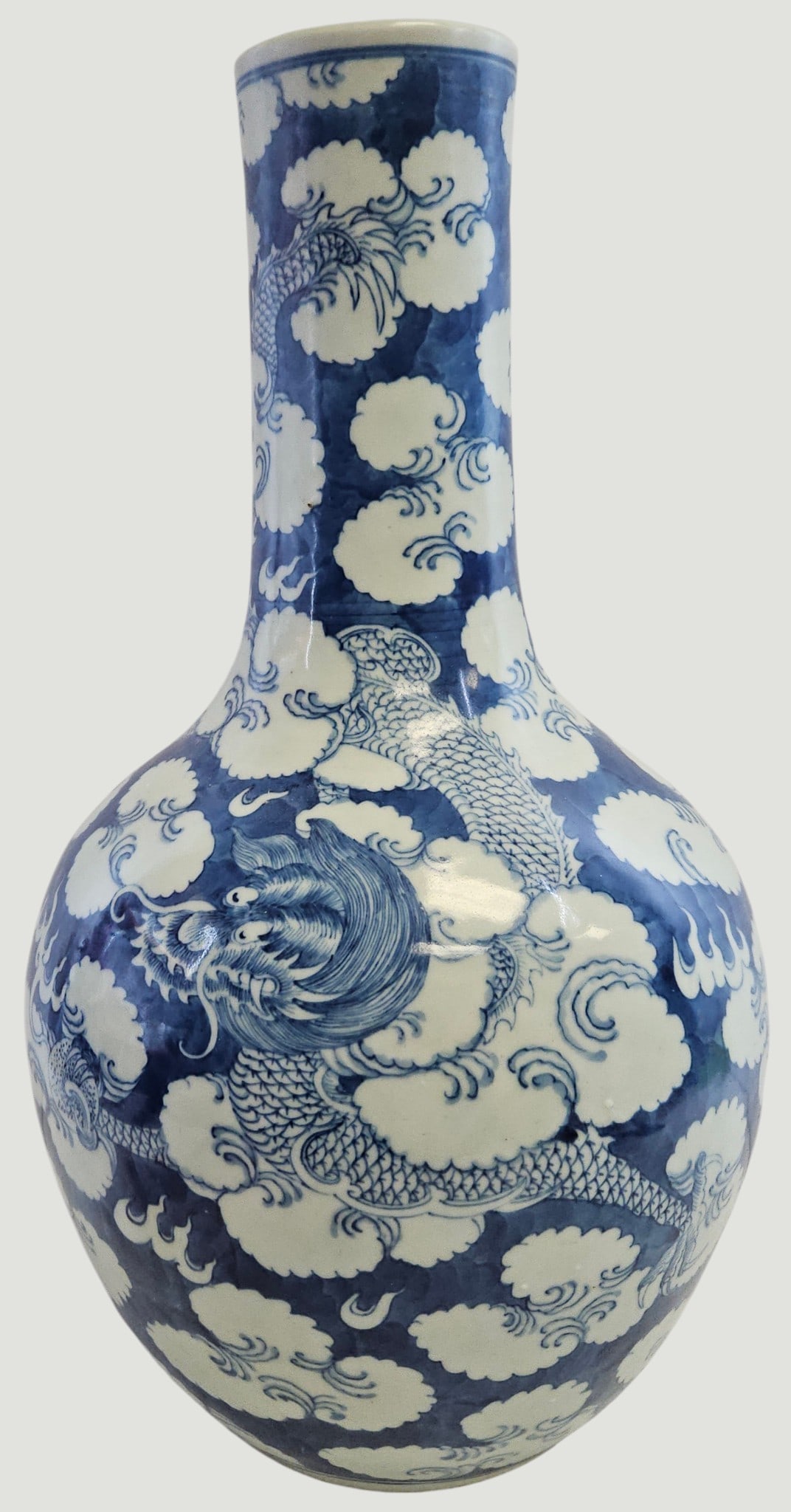 Large Qing Dynasty Blue & White Dragon & Cloud Tianqiuping Vase: Features a classic underglaze blue pattern of powerful, five clawed imperial dragon soaring amidst swirling auspicios clouds. Measures just shy of 18 inches high, 10 inches at its widest. Comes wiht