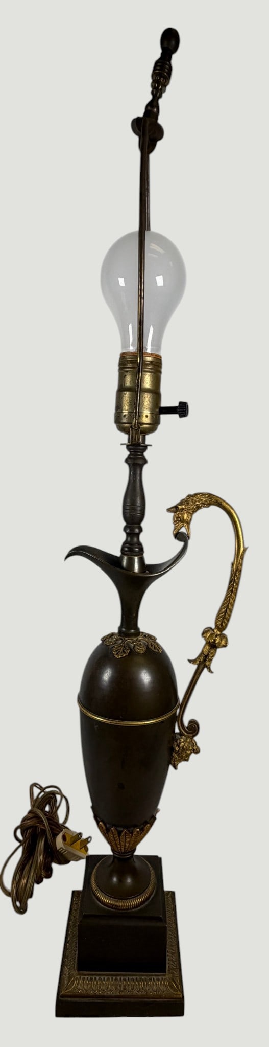 19th Century French Empire Style Bronze Ewer Lamp: Features a classic ovoid patinated bronze body, and elongated pinched everted spout, and a highly decorated high scrolling handle ending in a griffin's head terminal over the spout. The lower section