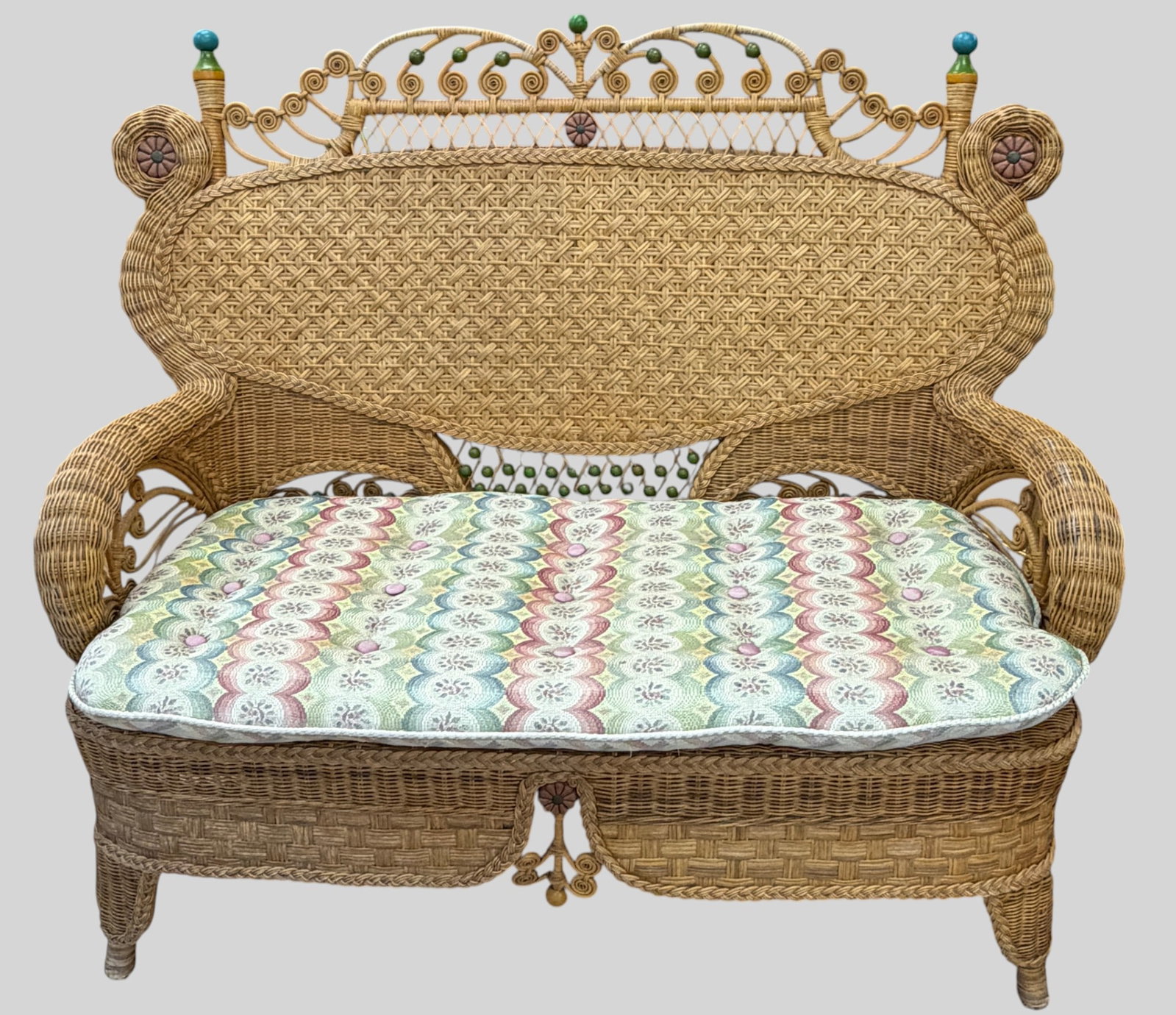 c1990 Mackenzie Childs Wicker Settee: An elaborate oversized fan style high back featuring an overarching, intricately woven cresting rail. The inner back contains a tightly stretched, expensive diamond-weave lattice panel supported by