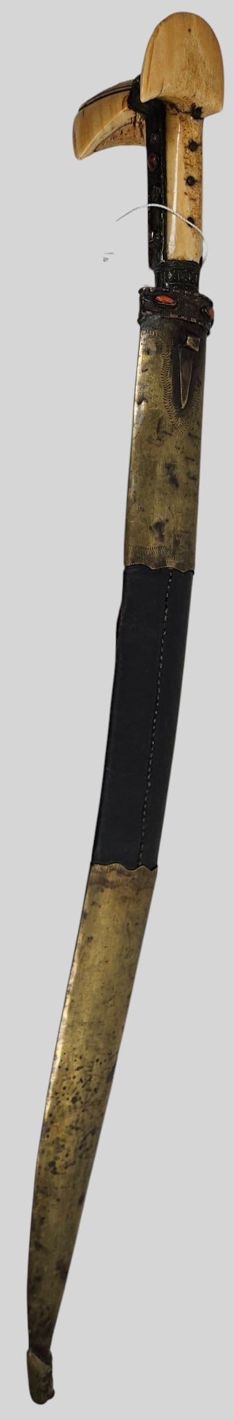 19th Century Ottoman Balkan Yatagan Sword with Coral Set Hilt & Original Scabbard: Featuring a traditional recurved, single edged carbon steel blade. The hilt boasts large, distinctively 'eared' pommel scales crafted from aged bone with incised geometric line accents, secured to the
