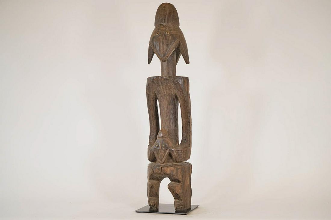 Jukun Figure on Base - Nigeria - African Tribal Art Sculpture: Measurements (inches) & Weight (pounds) Height: 36" Width: 8" Depth: 8.5" Weight: 27 lbs A standing figure holding a face between the hands and attached to a metal base.