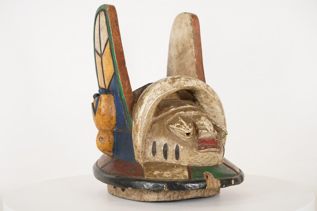 Yoruba Egungun Mask from Nigeria - African Tribal Art: Measurements (inches) & Weight (pounds) Height: 15.5" Width: 10" Depth: 13" Weight: 4.5 lbs An interesting colorful Yoruba Egungun style mask with two protruding horns on either side that have bir