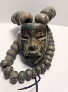 PRE-COLUMBIAN OLMEC NECKLACE WITH MASK PENDANT: PRE-COLUMBIAN OLMEC JADE NECKLACE WITH SERPENTINE MASK PENDANTMASKMEASURAMENT: 16" DIAMETER PENDANT FACE, 1 3/4" BY 1 1/2"1200BC-400BC