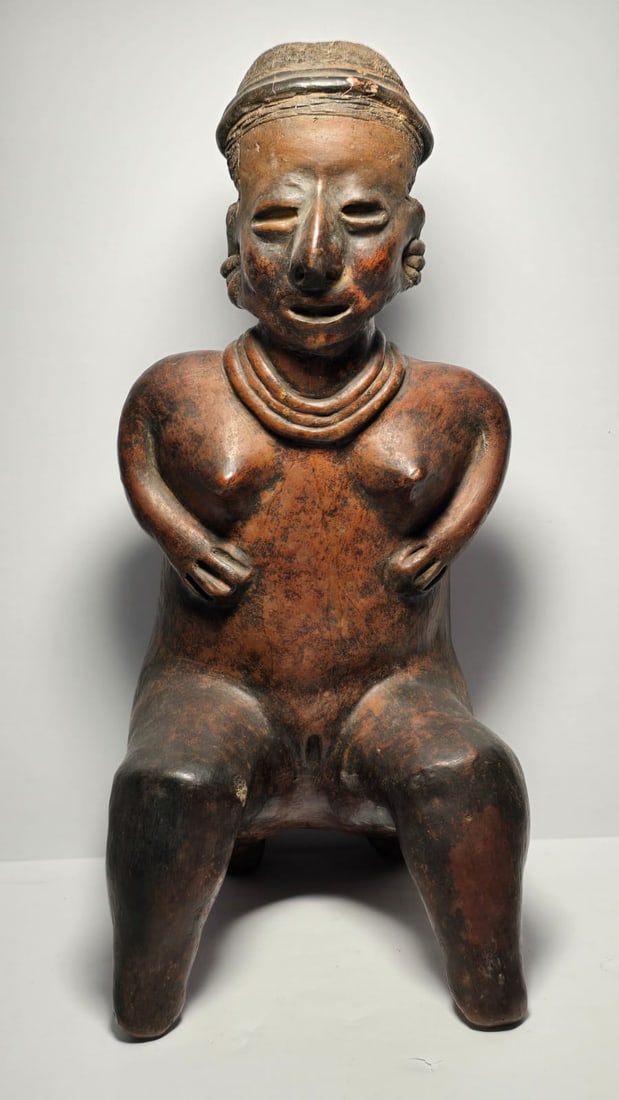 RARE PRE-COLUMBIAN NAYARIT TERRACOTTA SEATED WOMAN FIGURE: RARE PRE-COLUMBIAN NAYARIT TERRACOTTA SEATED WOMAN FIGUREA finely modeled terracotta seated female figure from the Nayarit culture of West Mexico, dating from 100 BC to 250 AD. The sculpture reflects