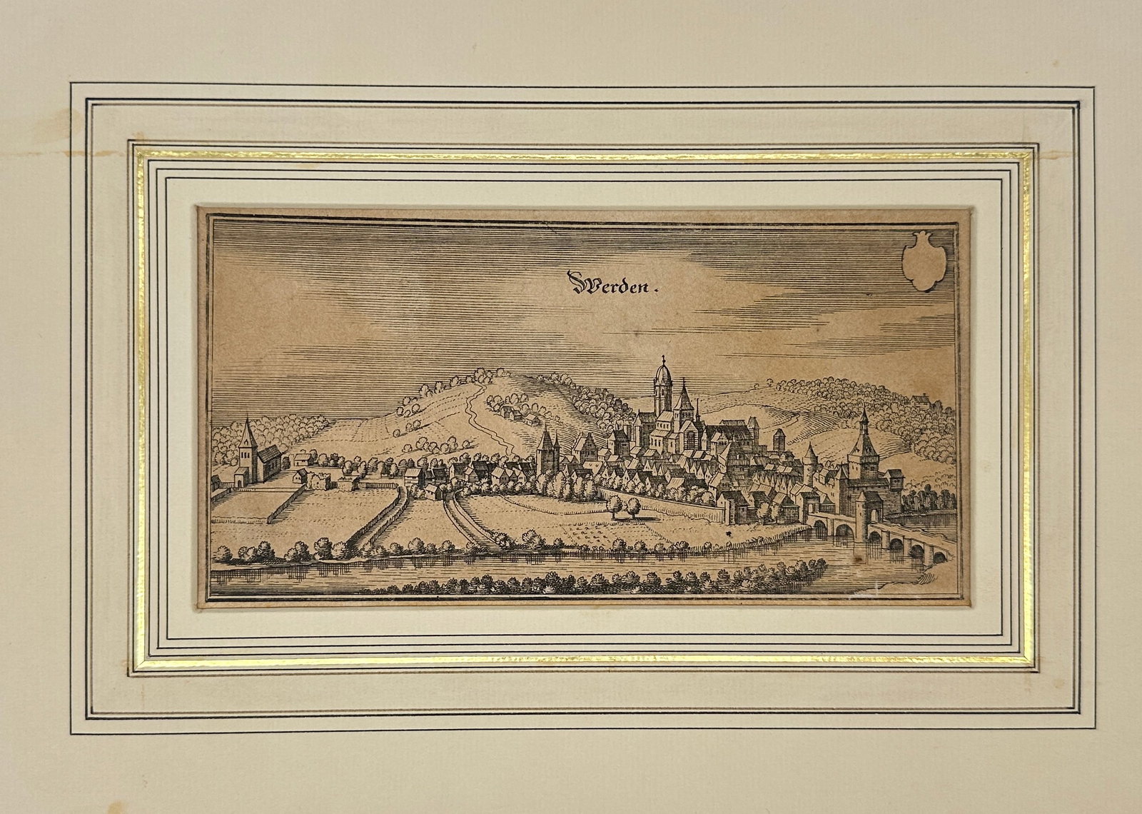Martin Zeiller (1589–1661) – View of Werden – From Topographia Westphaliae – Engraving: This antique engraving presents a panoramic view of the town of Werden, located on the Ruhr River in the historical region of Westphalia (Westphalen), Germany. The composition shows the town’s forti