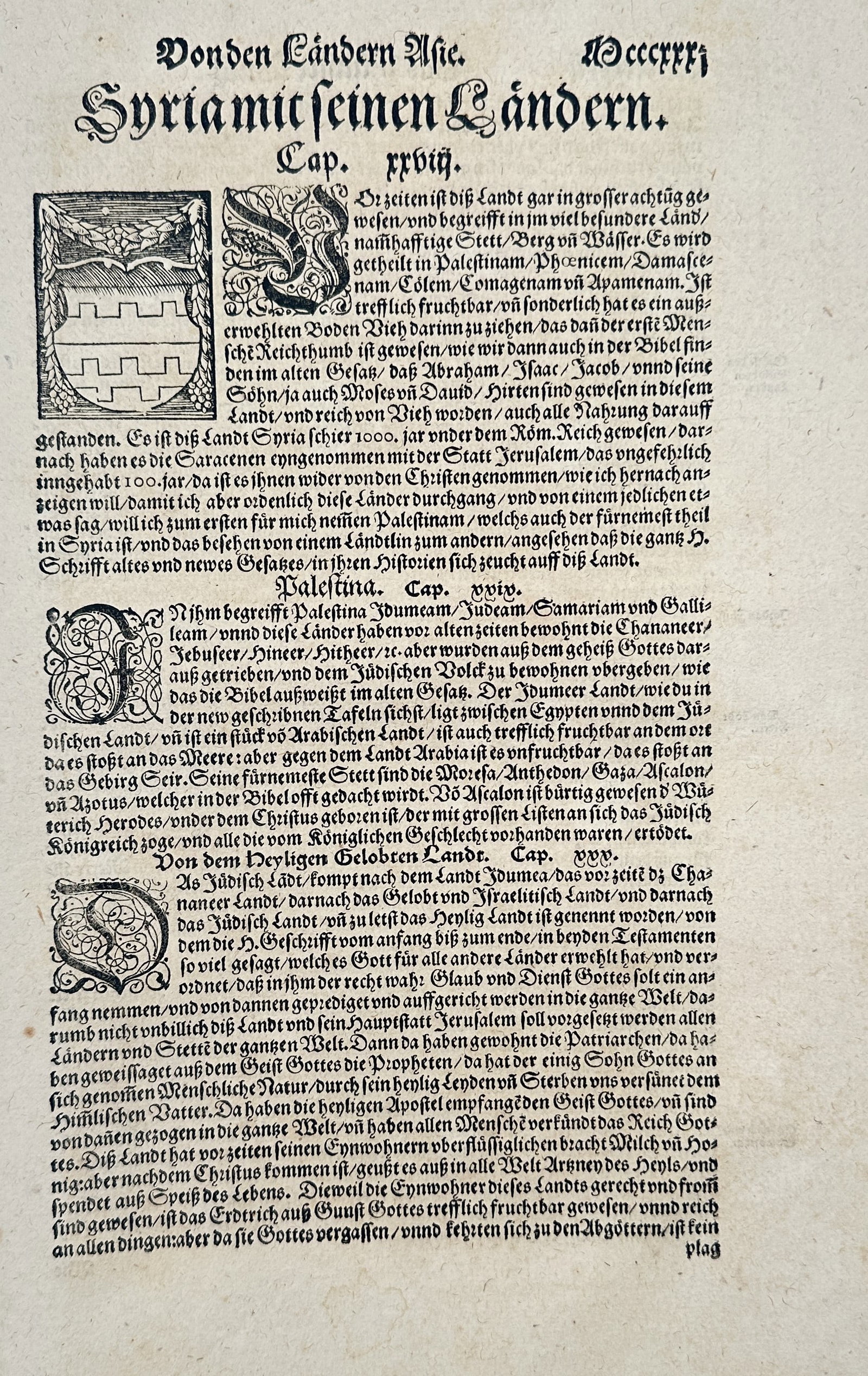 Sebastian Münster (1488–1552) – Syria and its Lands – Woodcut (1544): This woodcut illustration consists of a descriptive text page regarding the geography and history of Syria and the Holy Land, featuring a prominent coat of arms and decorative initial letters, publish