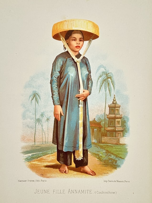Testu & Massin – Portrait of an Annamese Young Woman from Cochinchina – Chromolithography: "Jeune Fille Annamite" is a chromolithograph depicting a young woman from Cochinchina, Vietnam, standing in a tropical landscape. The subject is shown in traditional dress, wearing a long blue tunic o