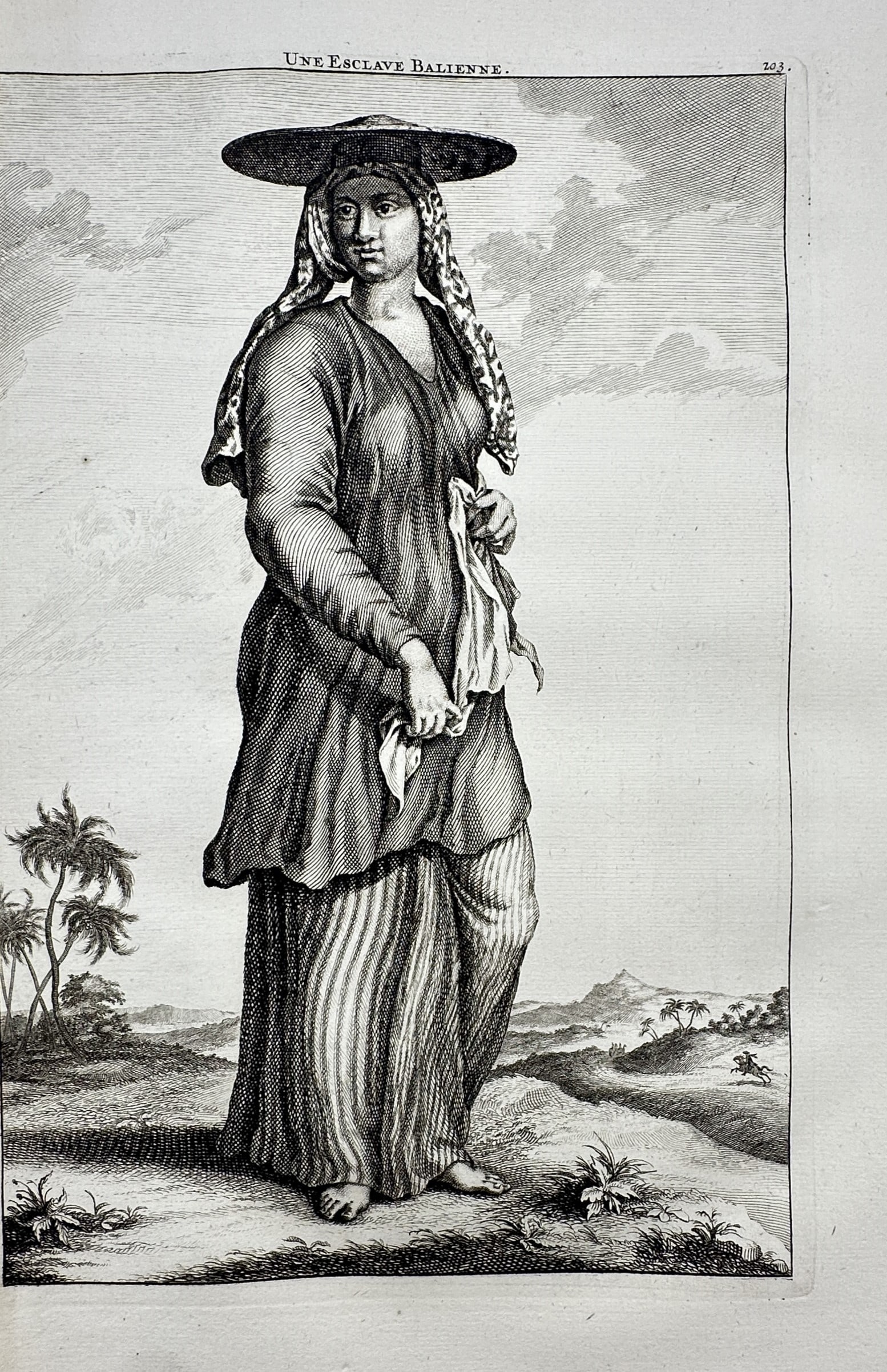 Cornelis de Bruijn (1652–1727) – View of a Balinese Slave – Copper engraving (1718): "Une Esclave Balienne" This ethnographic print depicts a woman in traditional Balinese attire, featuring a flat hat and patterned textiles, standing within a coastal landscape. The work is from Voyage