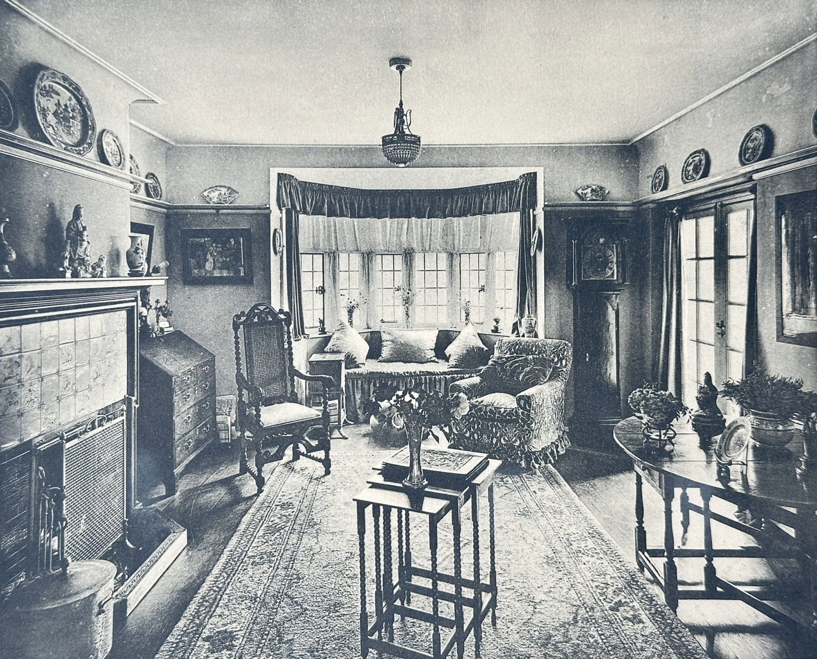 Thomas Millwood Wilson – Boudoir at Esher Park Residence – Collotype (1910): "The English Interior" This print features a view of a finely decorated private sitting room complete with comfortable armchairs, a large tiled fireplace mantelpiece, and a bright bay window. The resi