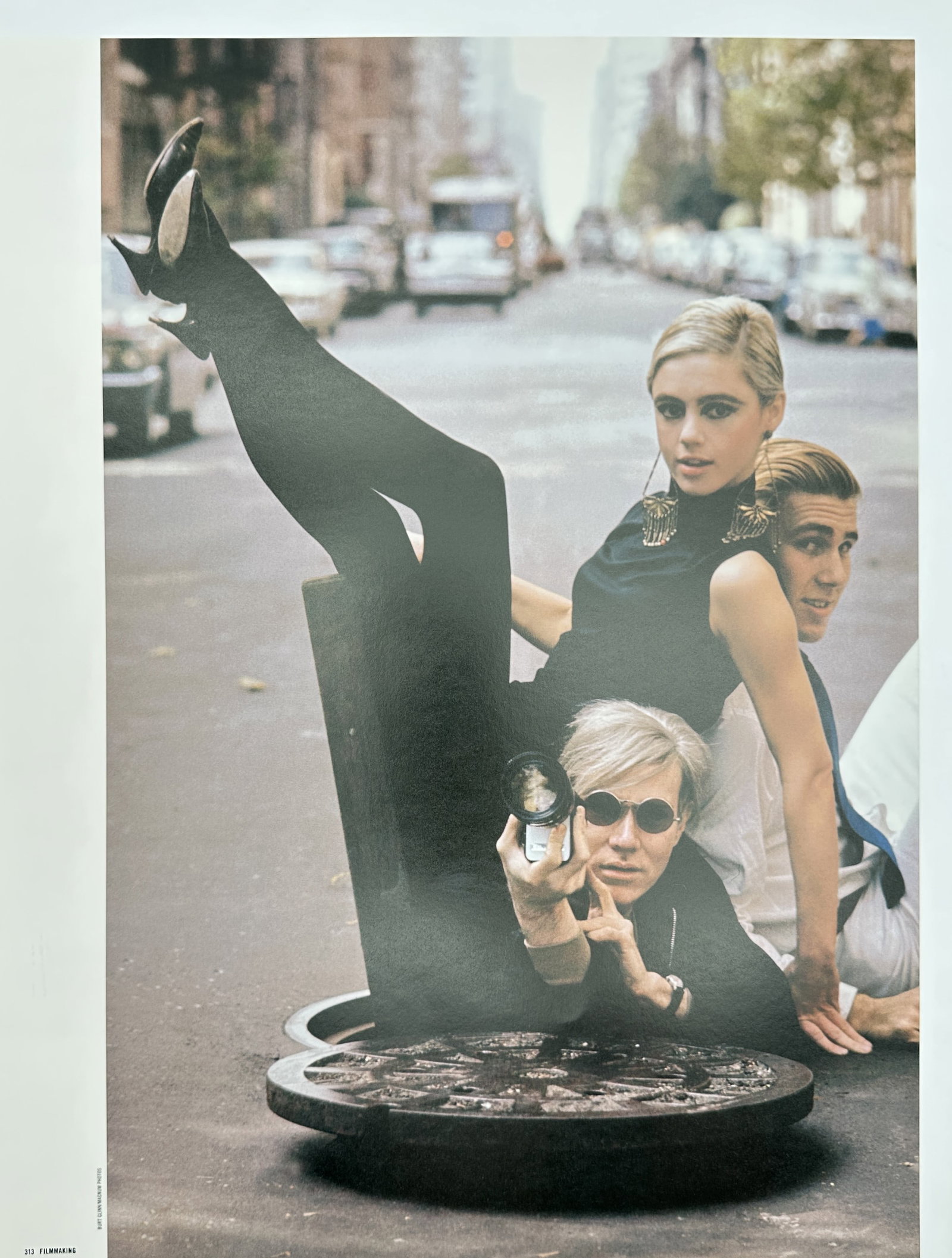 Andy Warhol,after – Andy Warhol, Edie Sedgwick, and Emerging From a Manhole: "Andy Warhol, Edie Sedgwick, and Emerging From a Manhole" This print features a famous photographic portrait depicting figures emerging from a street manhole on a New York City road. Published in 2006