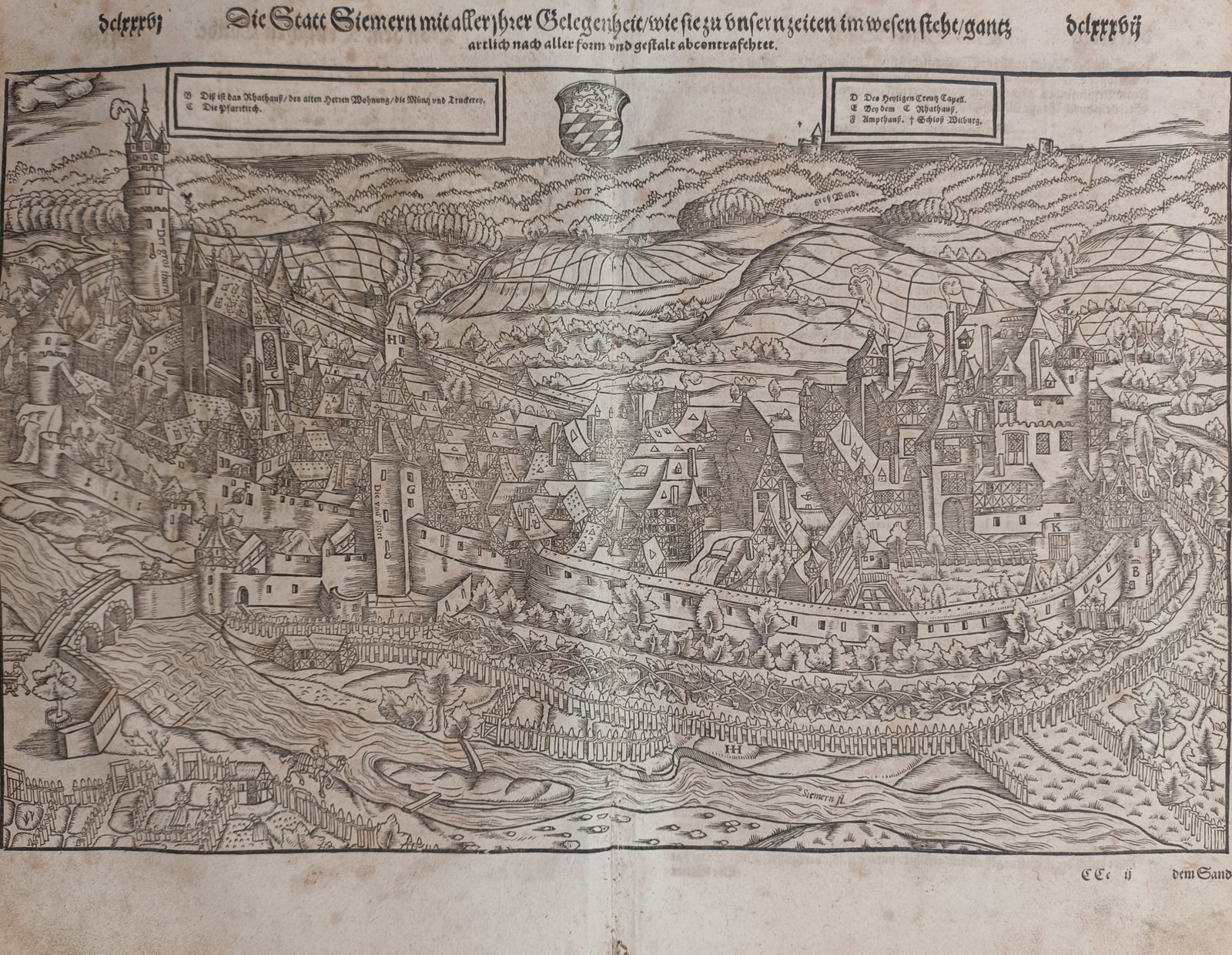 Sebastian Münster – Map of Simmern – Germany – Woodcut (16th Century): "Die Statt Siemern" presents a sixteenth-century topographical woodcut panoramic view illustrating the fortified German town of Simmern with its castle complex, defensive walls, watchtowers, and surro