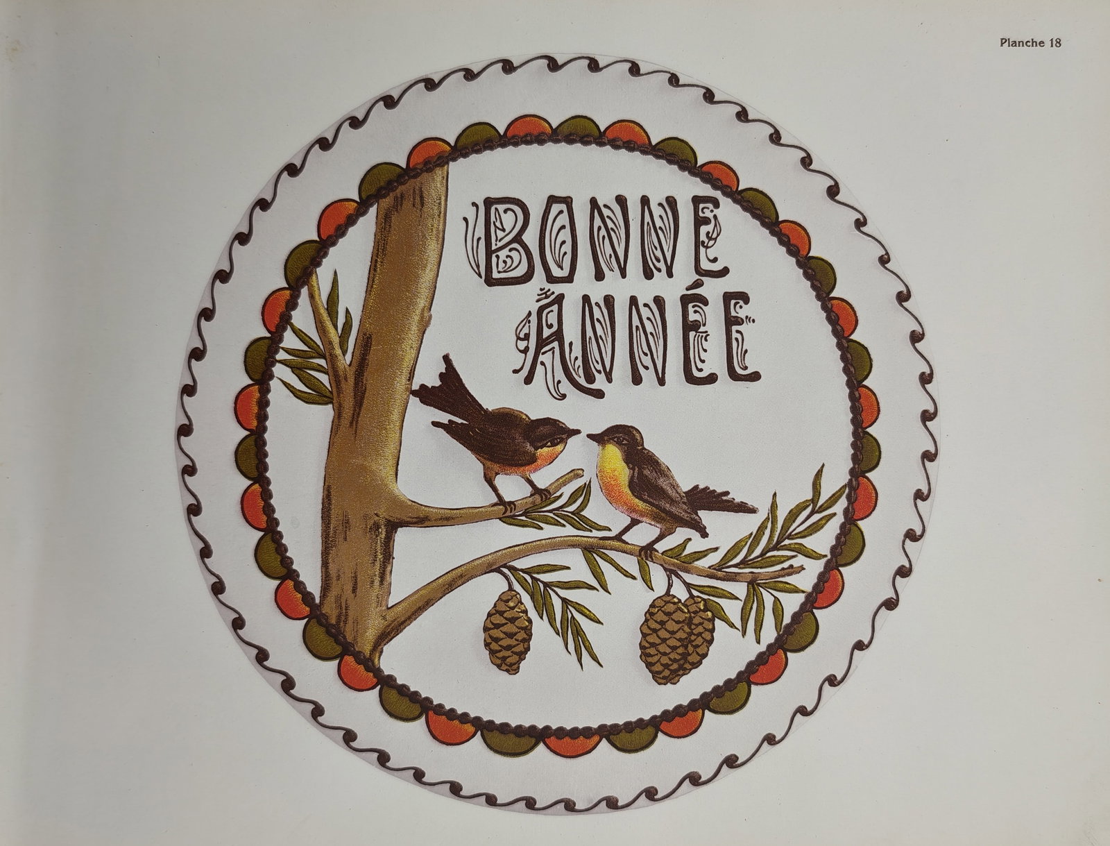 Thérèse de Dillmont – Happy New Year Embroidery Design – Lithograph (20th Century): "Happy New Year" This lithograph illustrates a circular embroidery or needlework pattern featuring a pair of birds perched on a pine branch with pinecones. The twentieth-century plate was published in