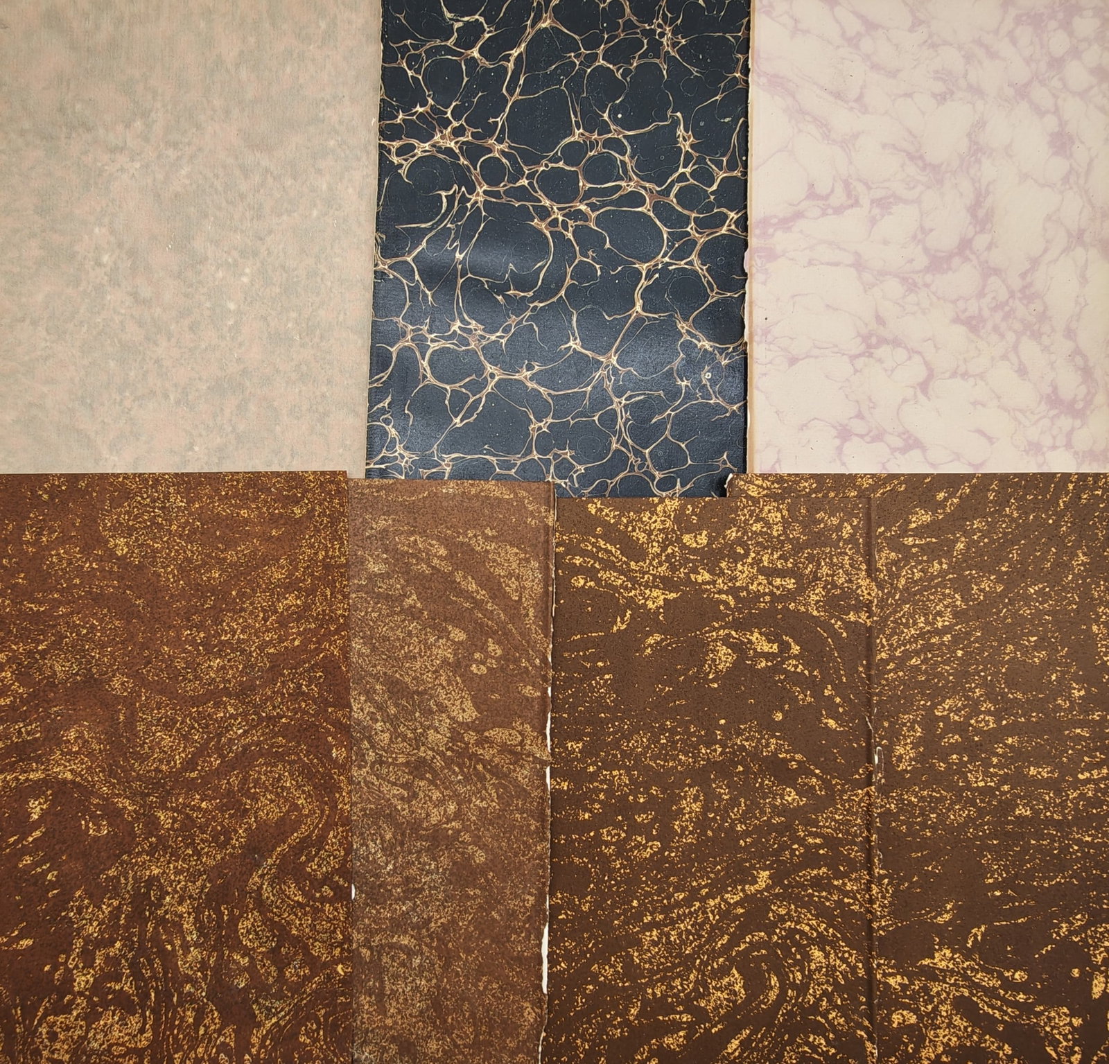 Unknown Artist – Set of 7: Spanish Vein, Stormont, and Paste Paper Decorative Sheets: "Antique Bookbinding Endpapers" presents a suite of seven decorative bookbinding sheets showcasing varied marbling techniques, including Spanish vein patterns on black, soft cloud and mottling motifs,
