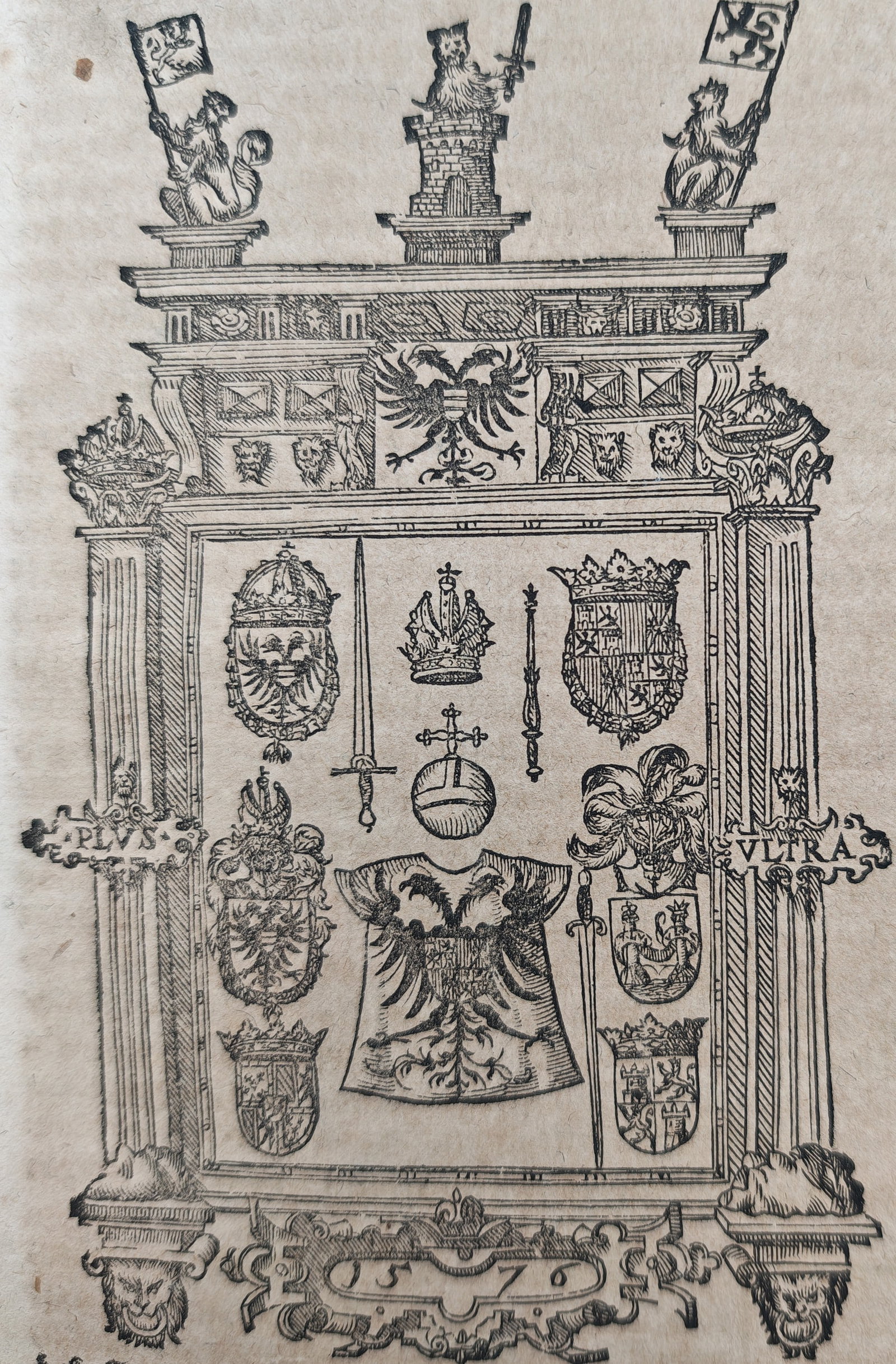 Sebastian Münster – Heraldic Insignia and Regalia of the Holy Roman Empire – Woodcut: "Heraldic Insignia and Regalia of the Holy Roman Empire" presents an ornate Renaissance architectural frame enclosing the imperial regalia—including the crown, imperial orb, sceptre, sword, and dalm