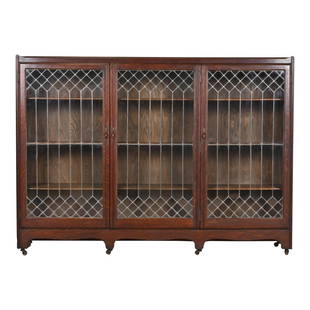 Antique Arts & Crafts Oak Leaded Glass Triple Bookcase by George C. Flint Co.: An exceptional antique Arts & Crafts or Mission triple bookcase By George C. Flint Co. New York, USA, Late 19th Century Quarter sawn oak, with original leaded glass doors and brass hardware. Measures: