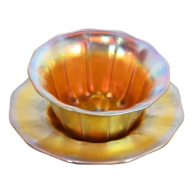 Steuben Aurene Iridescent Art Glass Finger Bowl With Underplate: A gorgeous Arts & Crafts or Art Nouveau period Aurene iridescent art glass finger bowl with underplate By Steuben Glass USA, Circa Early 20th Century Measures: Bowl: 5"W x 5"D x 2.5"H. Plate: 6.25"W x