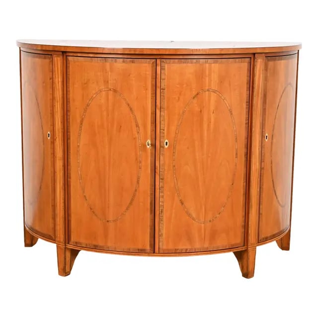 Baker Furniture Colonial Williamsburg Federal Inlaid Fruitwood Demilune Cabinet: A gorgeous Federal or Hepplewhite style demilune sideboard, cabinet, or console table By Baker Furniture, "Colonial Williamsburg" Collection USA, Circa 1980s Book-matched fruitwood, with beautiful wal